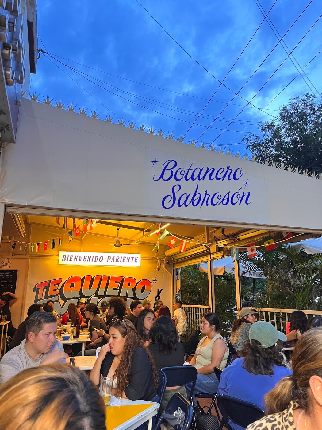 Fachada del Botanero Sabrosón con gente en las mesas
